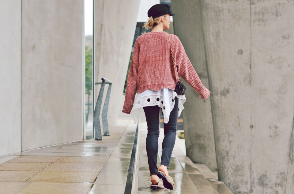 back view, pink knitted sweater, black pants, beige slippers
